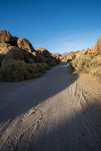 Road leading towards mountains against sky