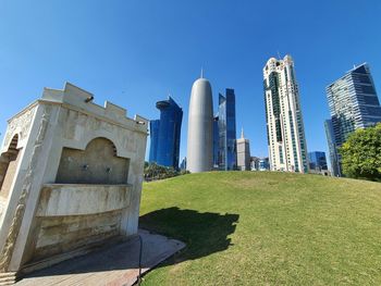 Low angle view of modern buildings against clear blue sky