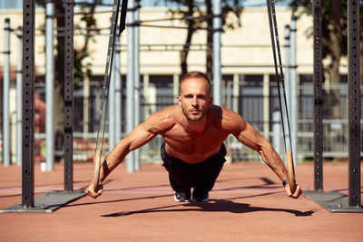 Portrait of young man exercising in city