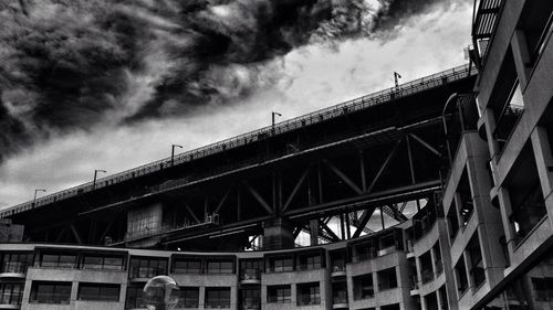 Low angle view of bridge against cloudy sky