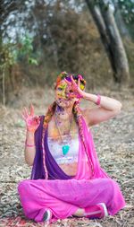 Portrait of woman with pink sitting on field