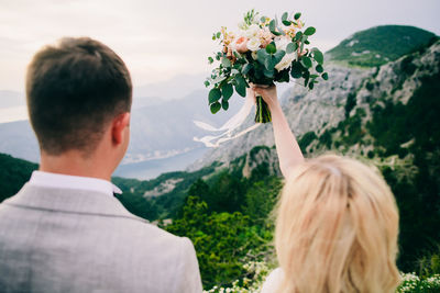 Rear view of woman with arms outstretched against mountains