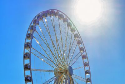 Low angle view of ferris wheel against blue sky