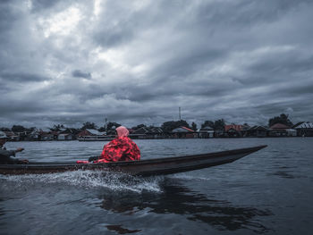 Rear view of woman on river against sky