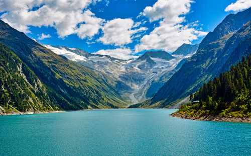 Scenic view of lake by mountains against sky
