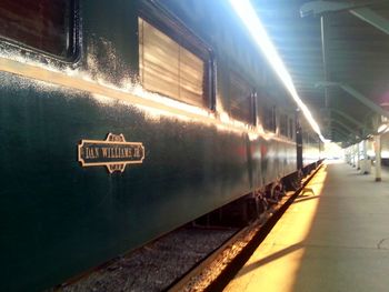 Train on illuminated railroad station against sky at night