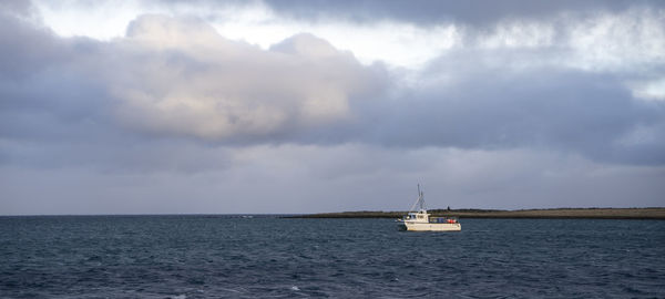 Sailboat sailing on sea against sky