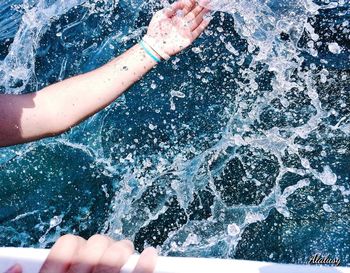 High angle view of hand splashing water in swimming pool