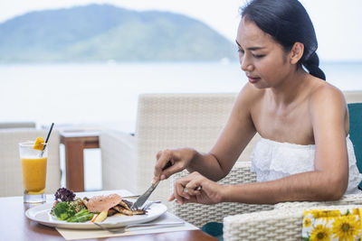 Woman eating at restaurant in luxury resort in phuket - thailand