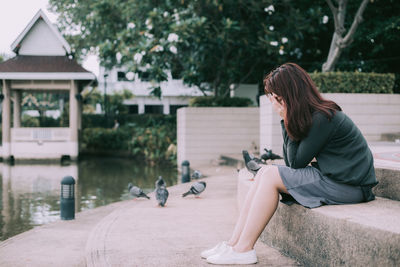 Side view of woman sitting outdoors