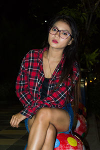 Portrait of young woman sitting outdoors