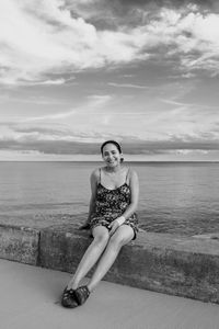 Portrait of young woman against sea against sky