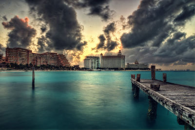 Pier by sea against sky during sunset