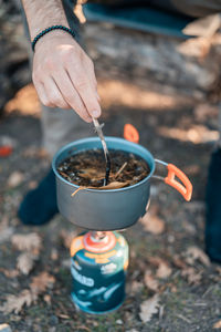 High angle view of person pouring tea cup