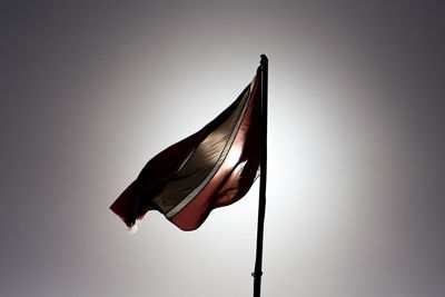 Low angle view of flag against clear sky during sunset