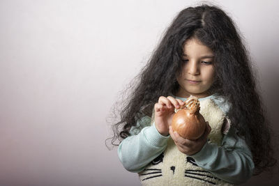 Girl holding ice cream cone against gray background