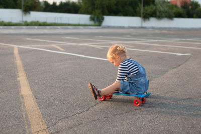 Full length of girl sitting on skateboard