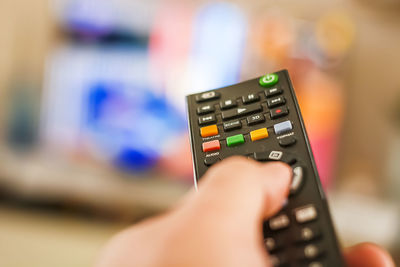 Close-up of person holding remote control