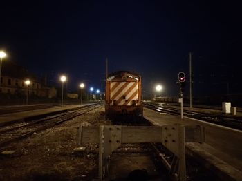 Train at railroad station against sky at night