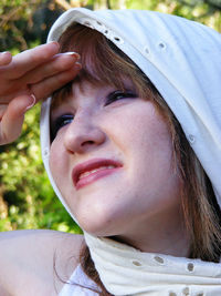 Close-up of woman wearing scarf while shielding eyes