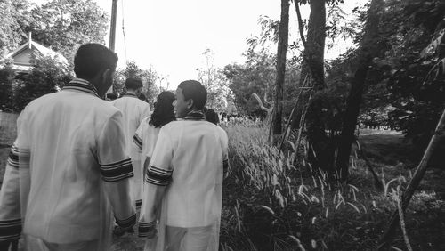 Rear view of people walking by plants