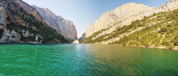 Scenic view of sea and mountains against clear sky