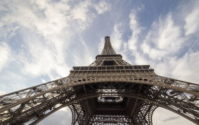 Low angle view of tower eiffel against cloudy sky