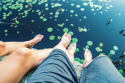 Low section of man and woman relaxing over water