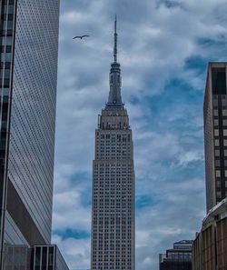 Low angle view of modern building against cloudy sky