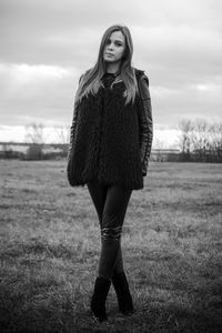 Portrait of young woman standing on field