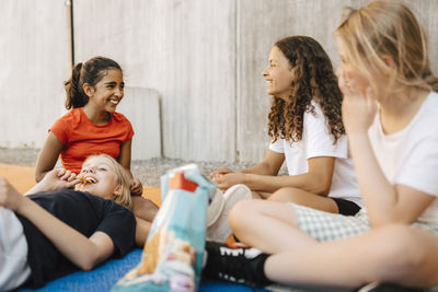 Happy multi-ethnic girls having snack at basketball court