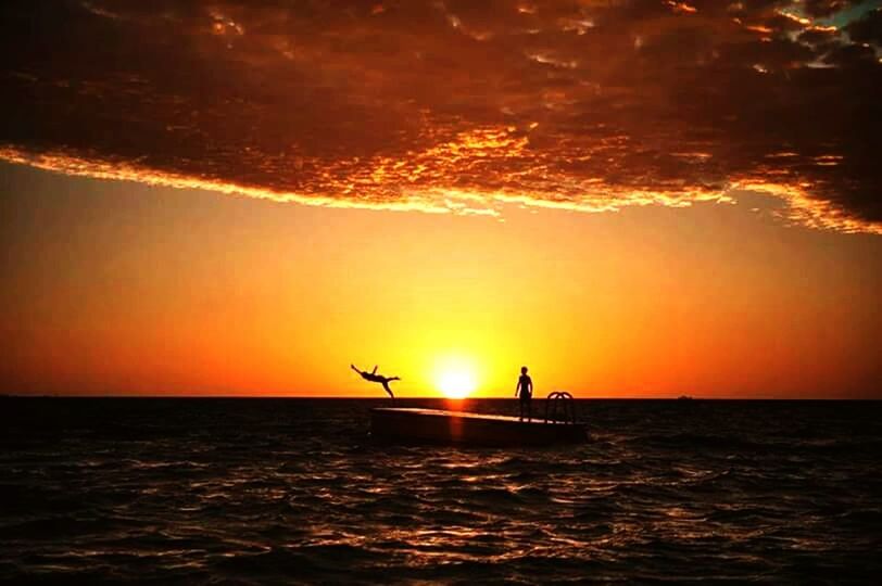 sunset, silhouette, sea, water, sun, orange color, scenics, horizon over water, beauty in nature, tranquil scene, waterfront, sky, tranquility, idyllic, nature, flying, unrecognizable person, rippled