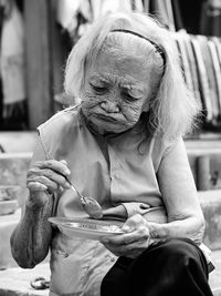 Close-up of senior woman eating outdoors