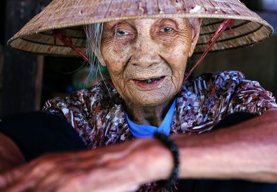 Close-up portrait of senior woman wearing hat sitting at home