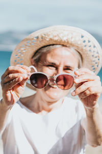 Portrait of young woman wearing sunglasses at home