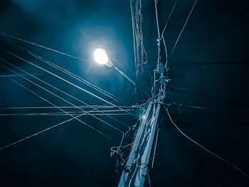 Low angle view of illuminated lights against sky at night