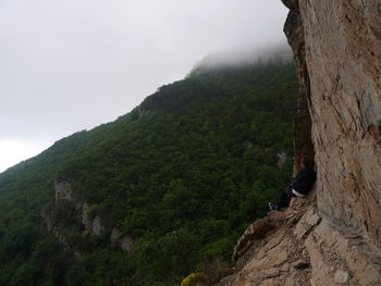 Rear view of woman sitting on mountain