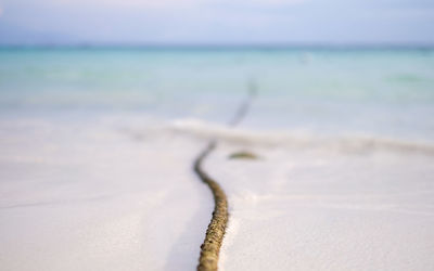 Close-up of wave on beach against sky