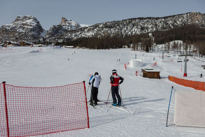 People skiing on snow covered field