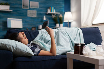 Man lying on sofa at home