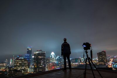 Woman standing in illuminated city at night