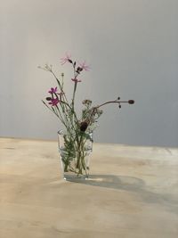 Close-up of flower vase on table against wall