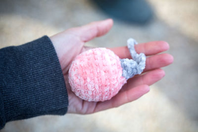 Cropped hand of woman holding woolen bauble