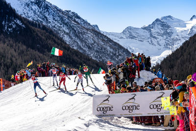 People on snow covered mountains against sky