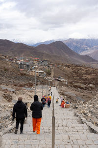 Rear view of people walking on mountain