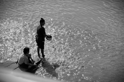 Rear view of people enjoying in sea