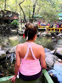 Rear view of woman in river against trees