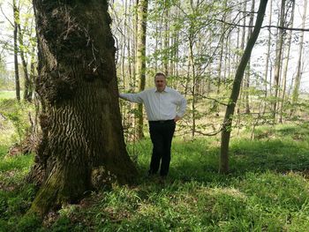 Full length of man standing on tree trunk