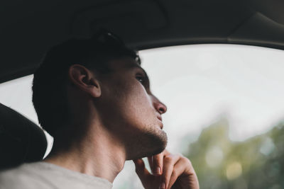 Portrait of a young guy driver in the car.