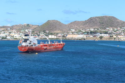 Boats in sea with town in background